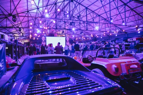 Evenement Sikkens organisé au Hangar 125 et vue sur la salle avec voitures et clients qui boivent un verre